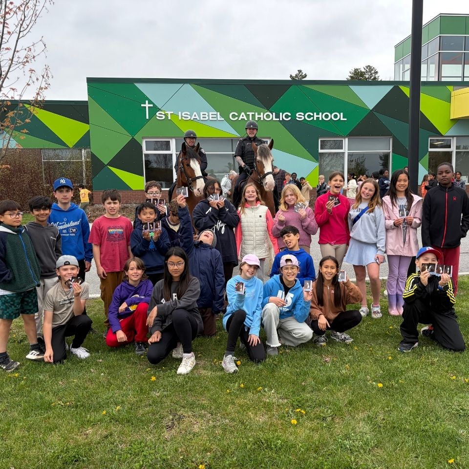 Students with two mounted unit horses in front of school
