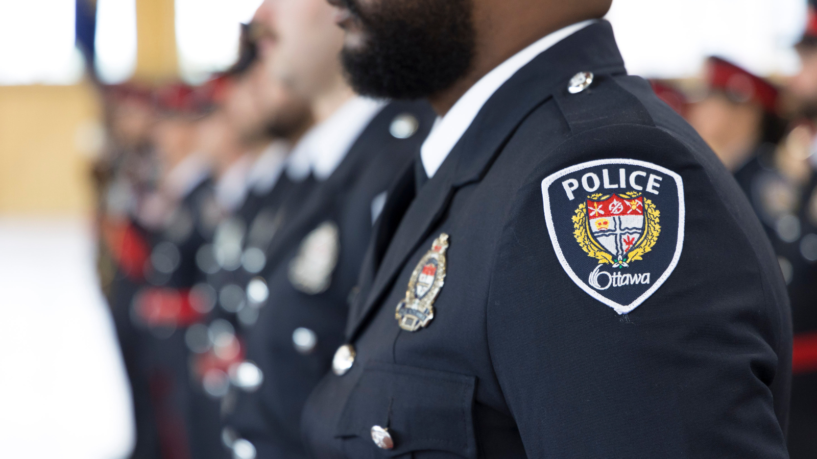 Officer standing at attention in dress uniform.