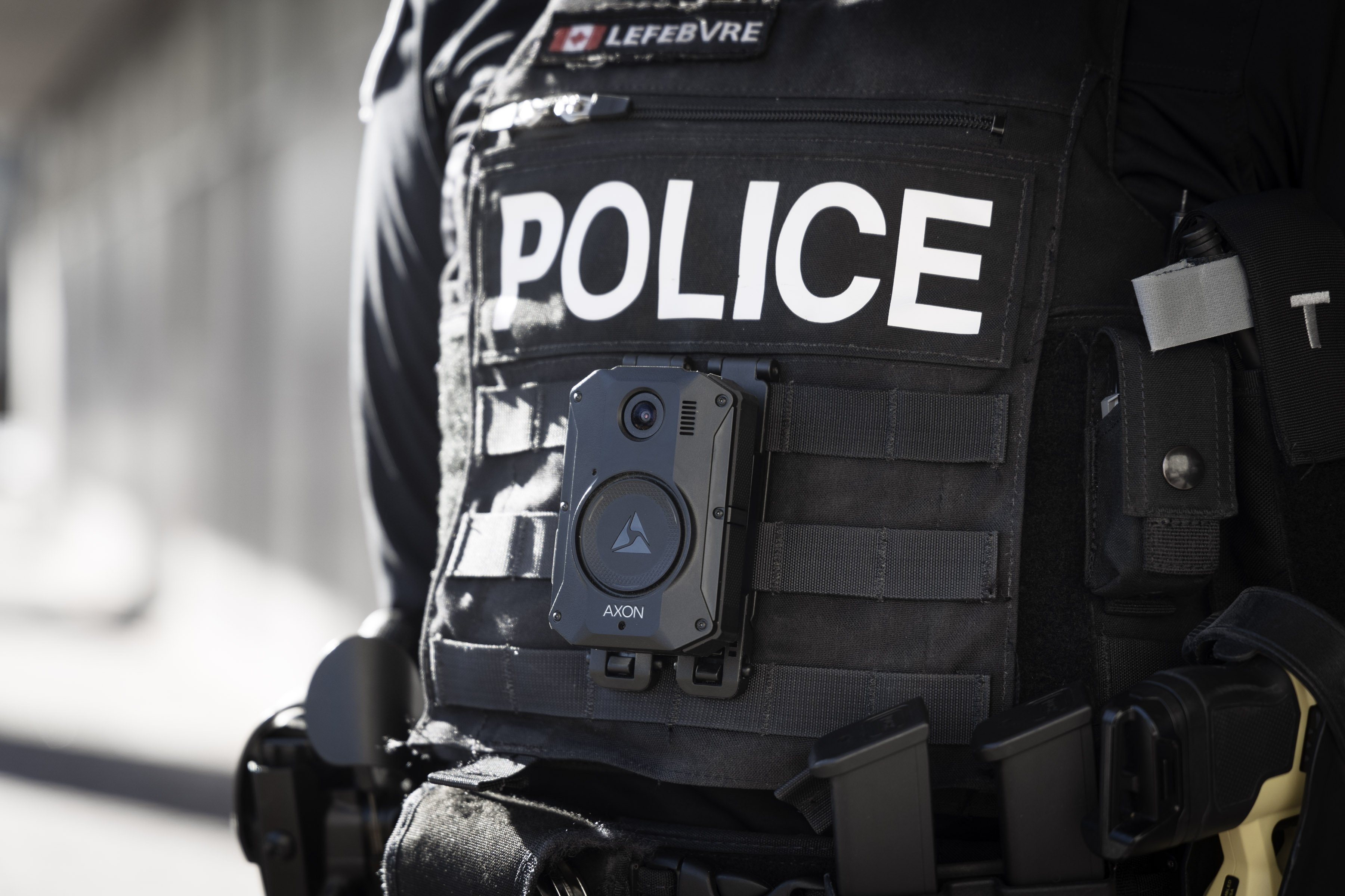 Photo of a police officer's uniforn, including a body worn camera affixed to the front vest.