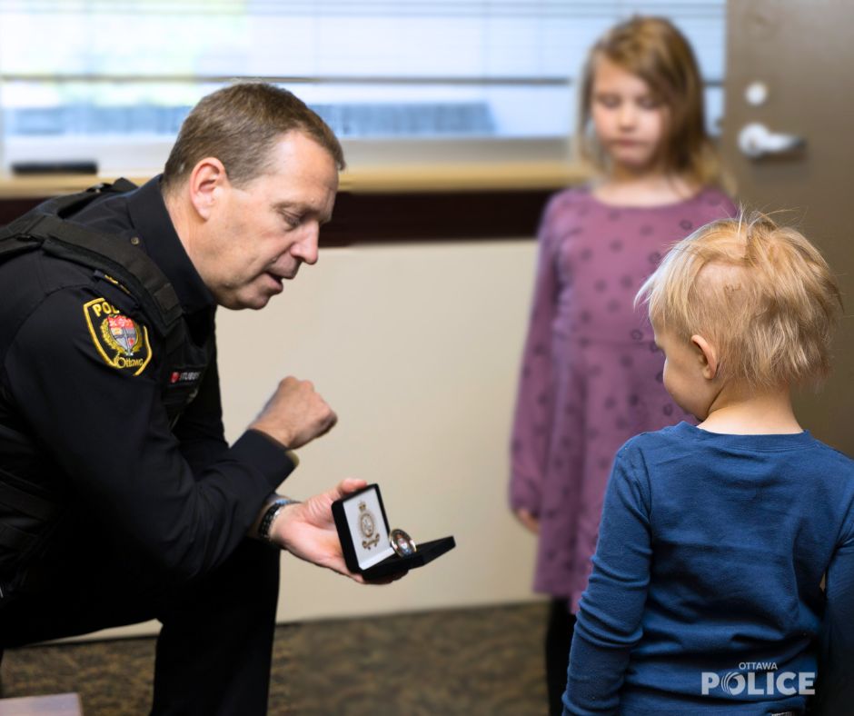Chief Eric Stubbs presents Jack with a challenge coin for bravery