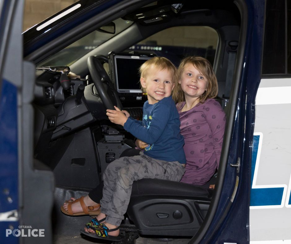 Jack and his sister Tessa exploring a police cruiser.