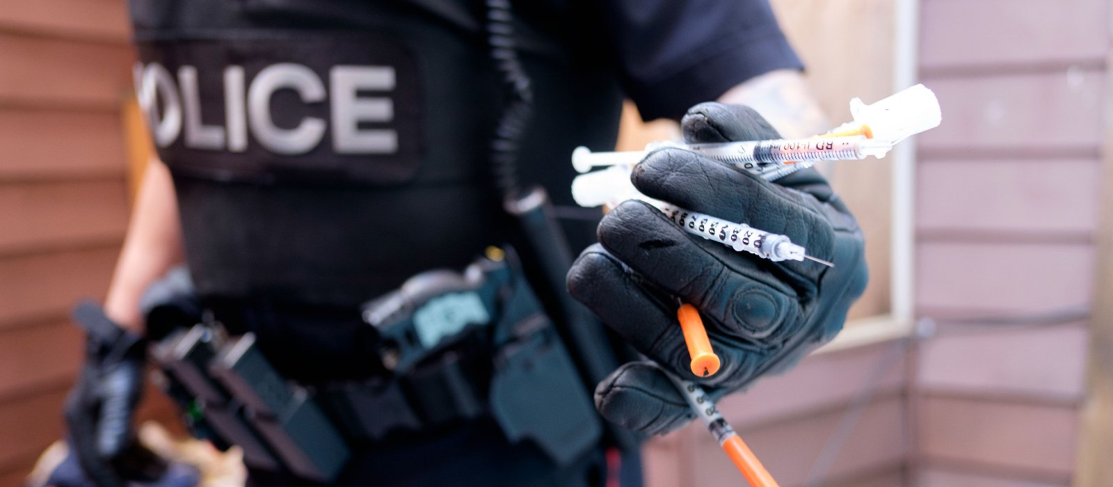 Un agent du Service de police d'Ottawa collecte les seringues usagées qu'il trouve en patrouille.