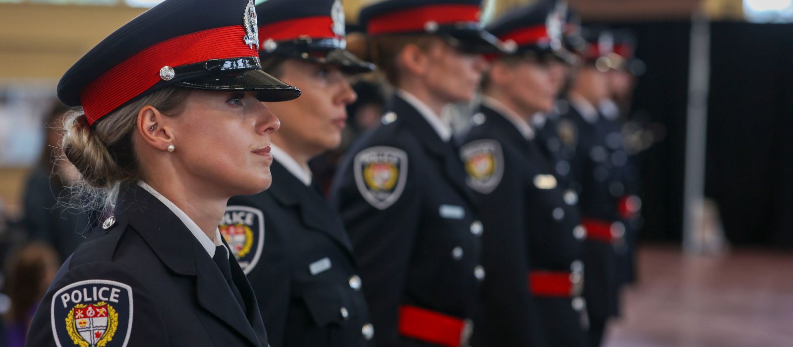 A group of new officers stand in line at their badge ceremony.