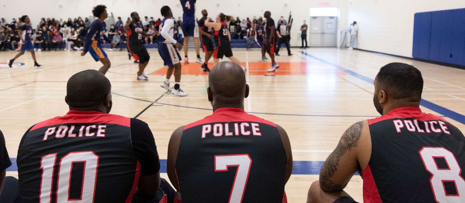 Hoopstars players watching a basketball game.