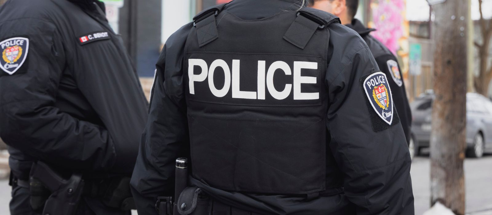 A group of three Ottawa Police officers standing outside talking.