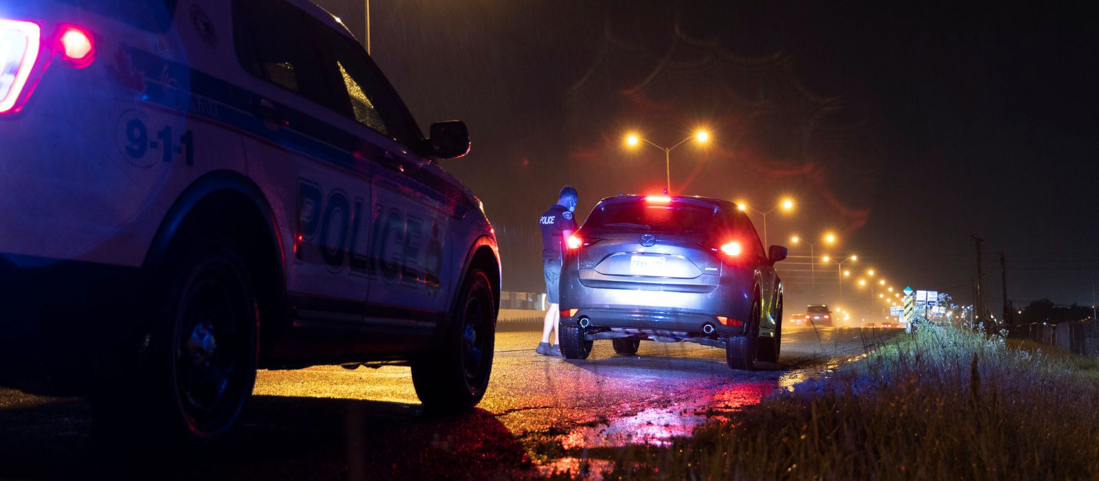 Police conducting a traffic stop at night.