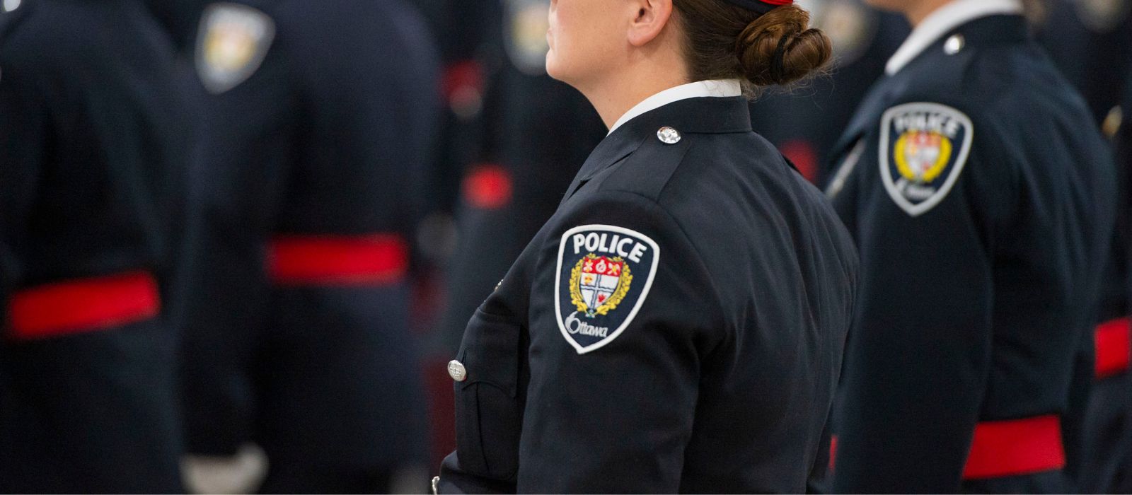 Un membre du Service de police d'Ottawa se tient au garde-à-vous dans son uniforme officiel.