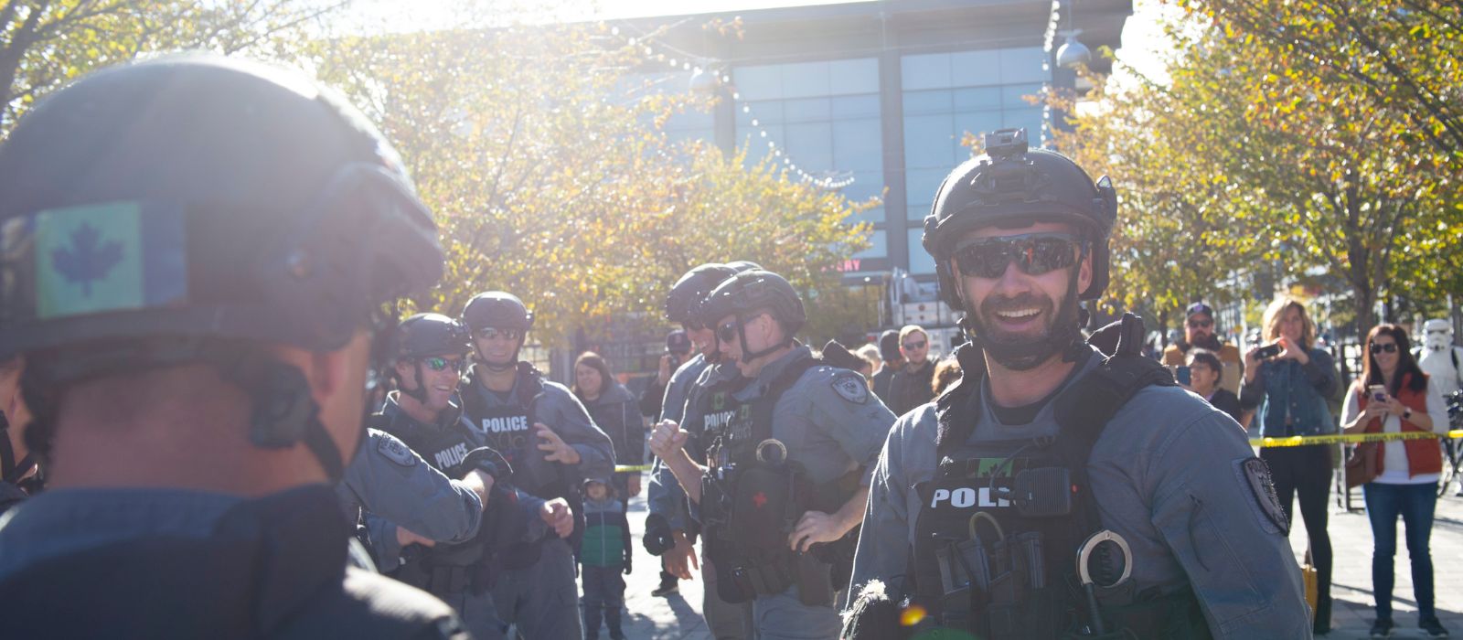 Members of the Ottawa Police Tactical Unit stand outside in a group in the summertime.