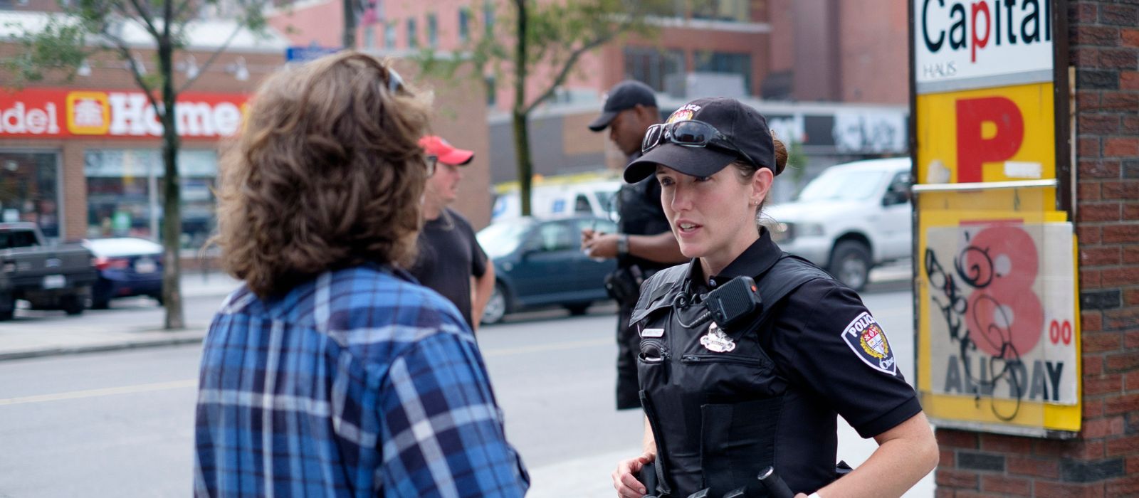 Two Ottawa Police officers have separate discussions with some members of the public. 