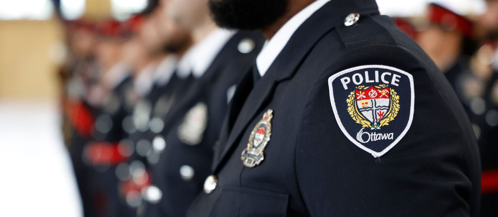 Line of Ottawa Police members in their formal uniforms at their badge ceremony.