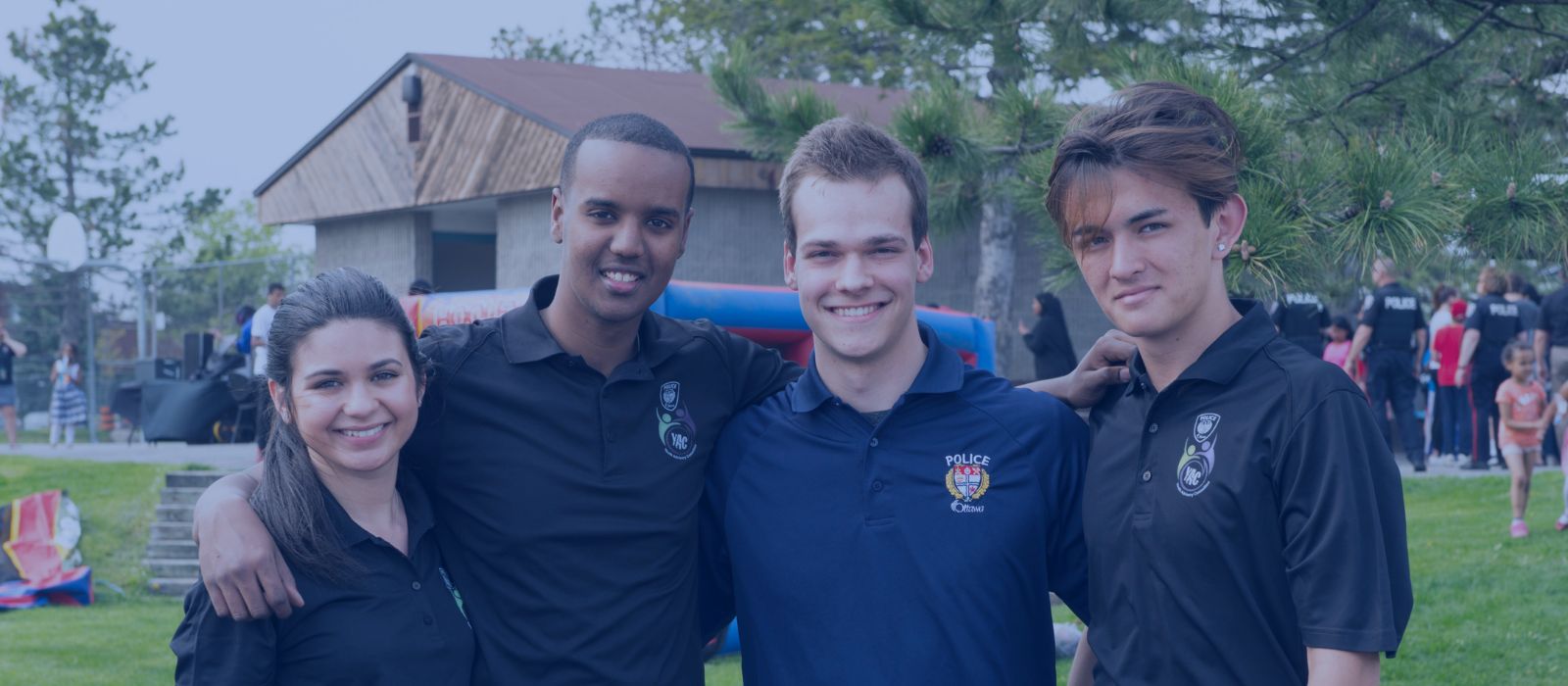 Group of Youth Advisory Committee members with their arms around each other’s back while smiling. 