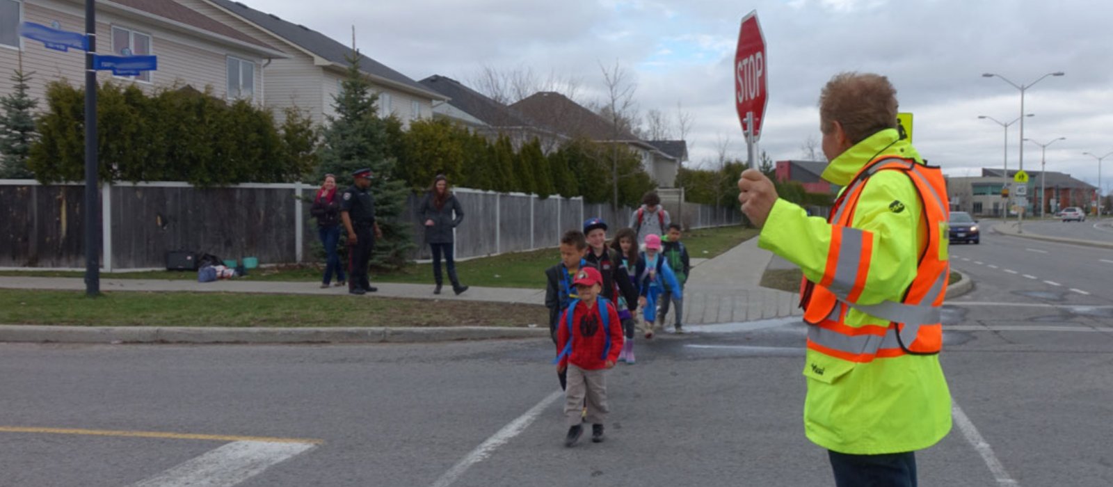 A crossing guard helps children safely cross the street