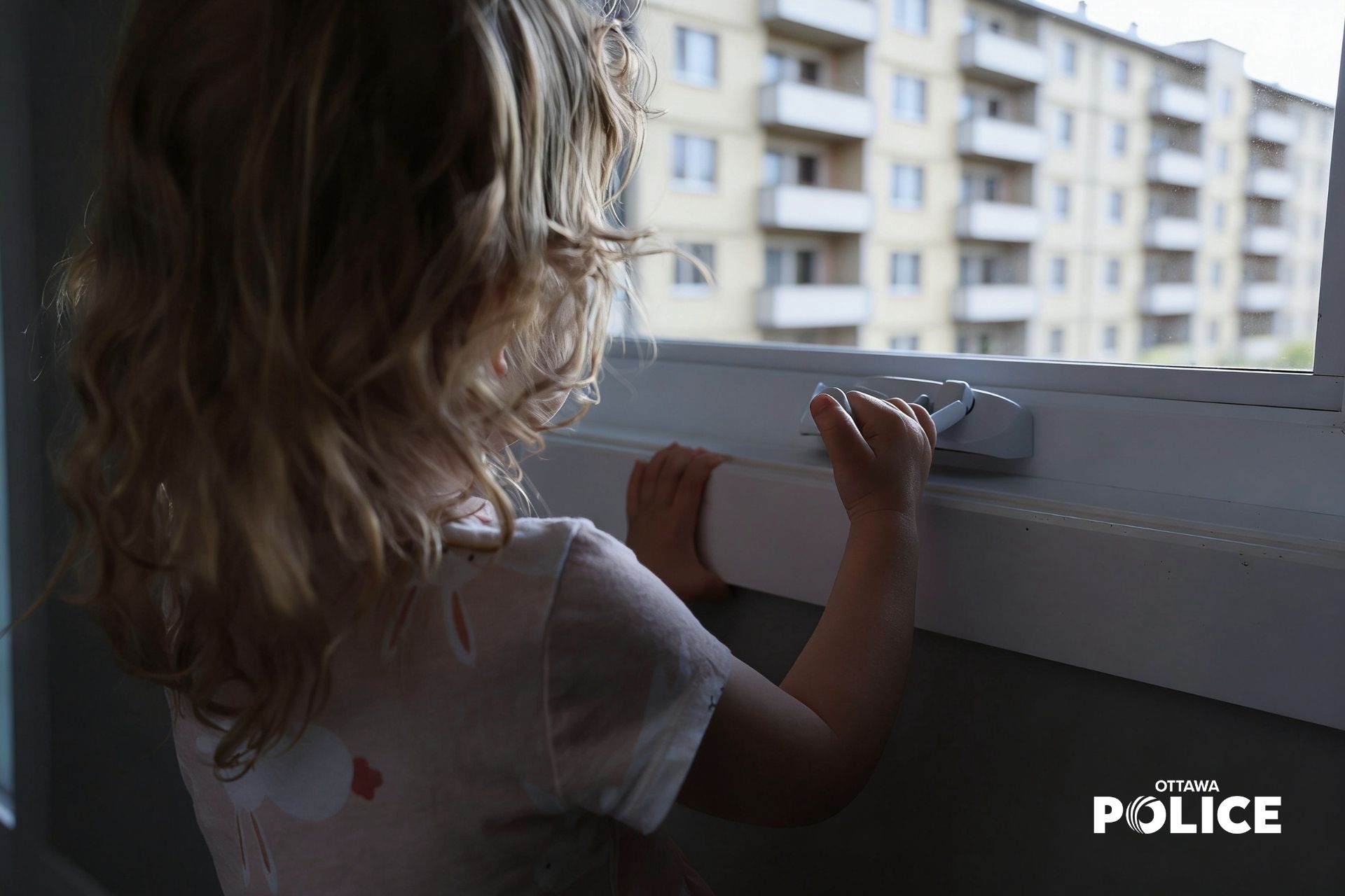 Child looking out the window of an apartment building