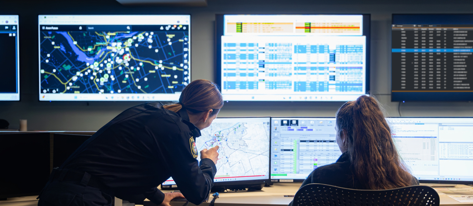Two people looking at information on computer monitors