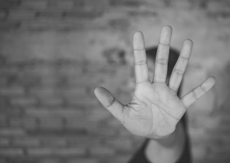 Hate-motivated incident: A person holding a handout in front of their face.