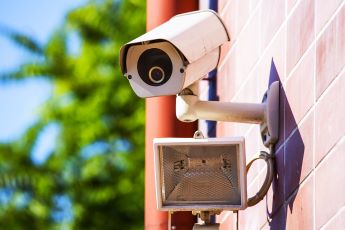 Security camera pointing at a property from the side of a building