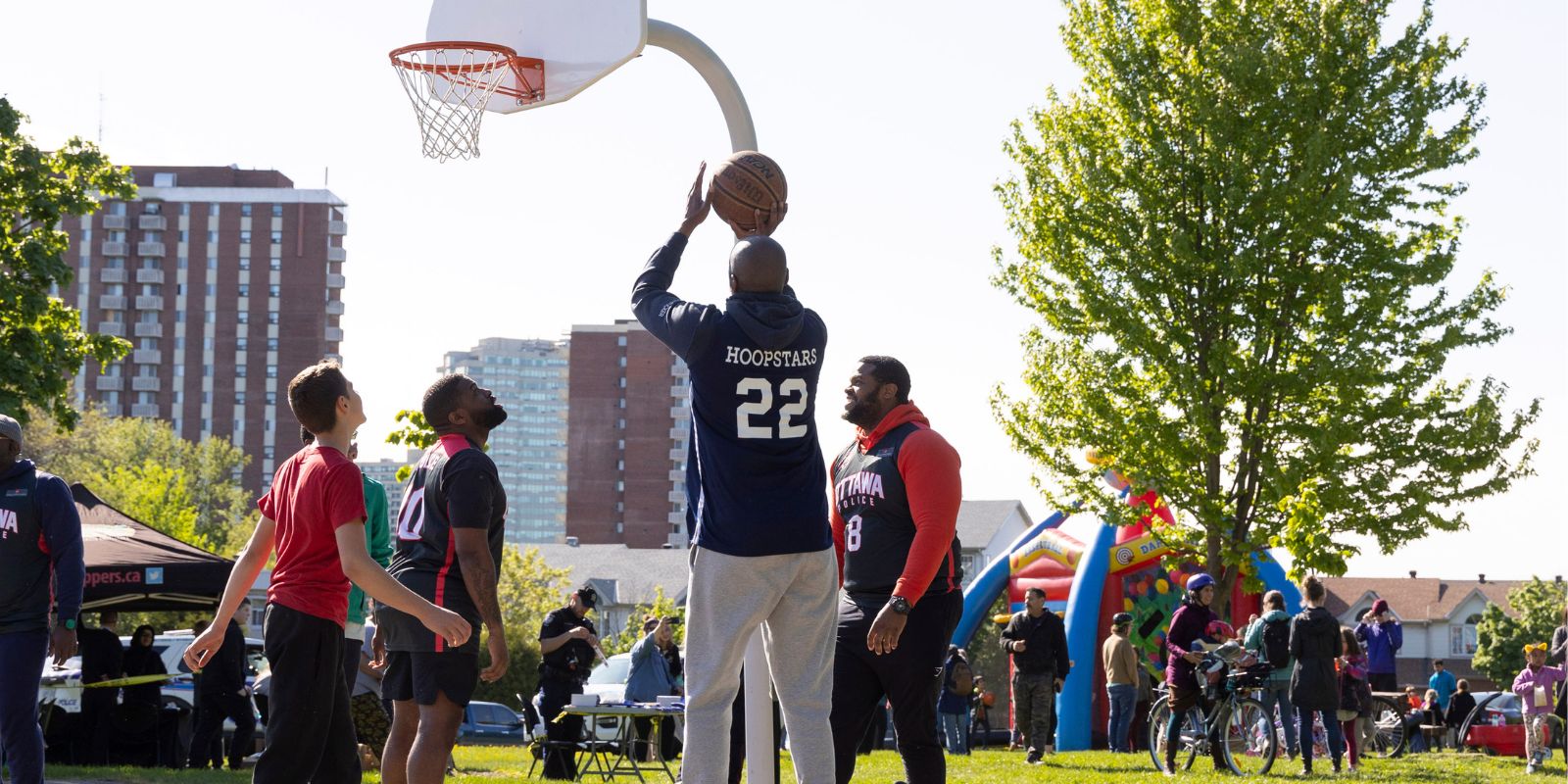 Hoopstars playing basketball with members of the community during an outdoor community event