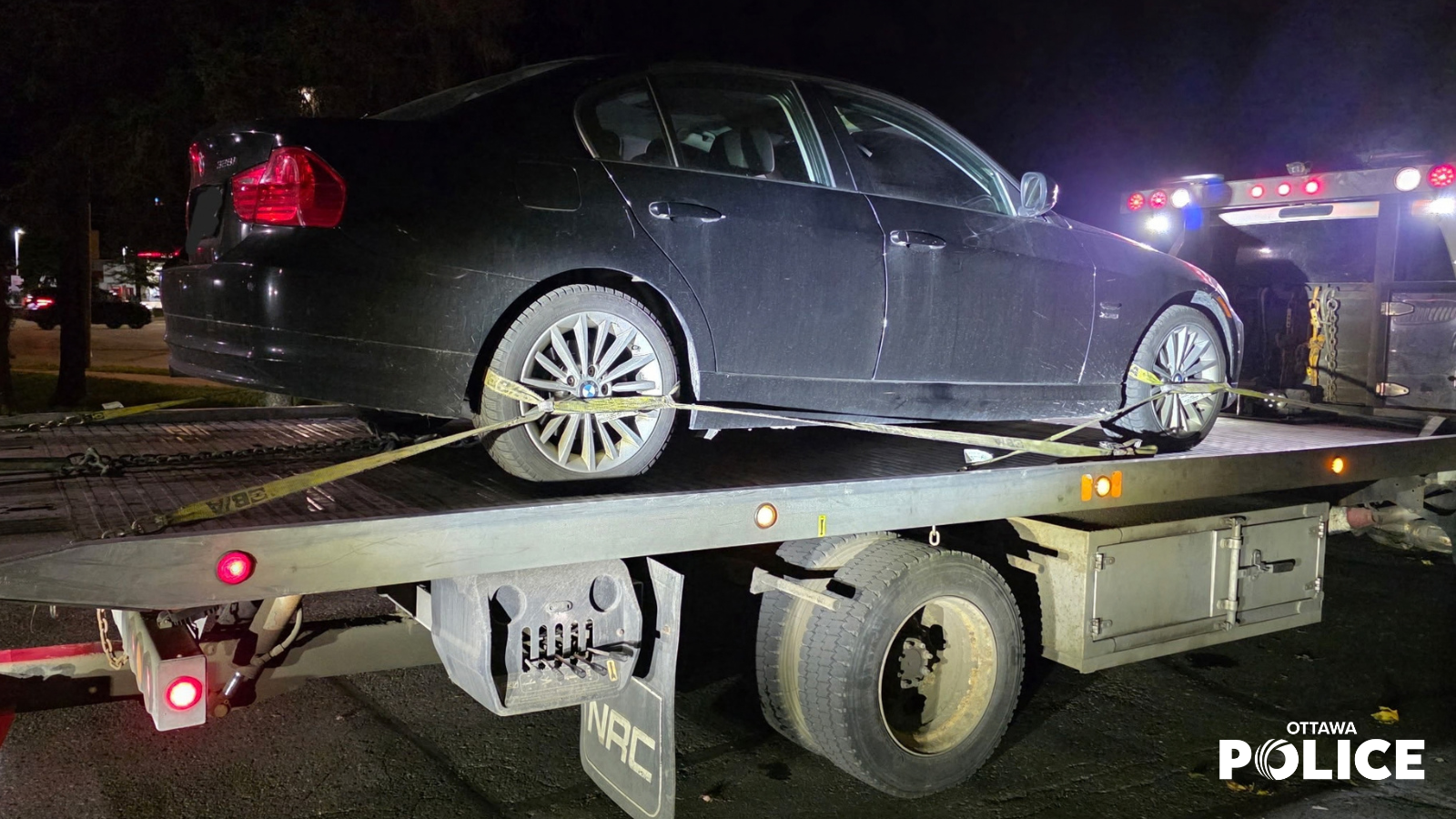 Vehicle on the back of a flatbed tow truck