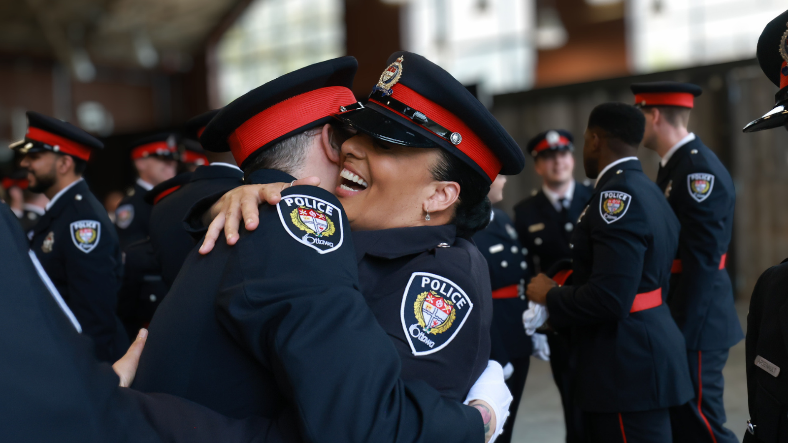 Deux agents s'étreignant lors d'une cérémonie de remise des insignes organisée par le Service de police d'Ottawa