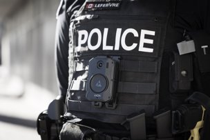 Photo of a police officer's uniforn, including a body worn camera affixed to the front vest.