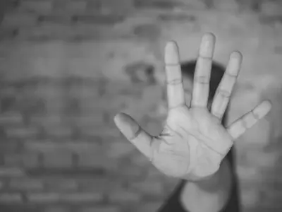 Person holding out their hand, obscuring their face / Une personne tendant la main, le visage caché
