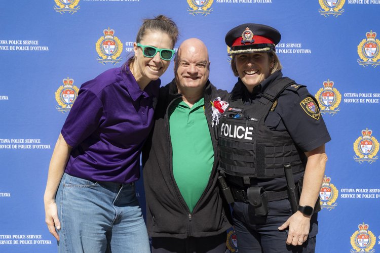 Richard, Robin and DC Patricia Ferguson in front of an OPS backdrop at his retirement send off.