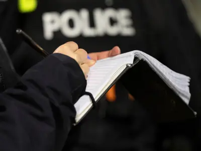 Ottawa Police officer taking notes during a conversation with the public. / Un agent de police d'Ottawa prend des notes pendant une conversation avec un membre du public.