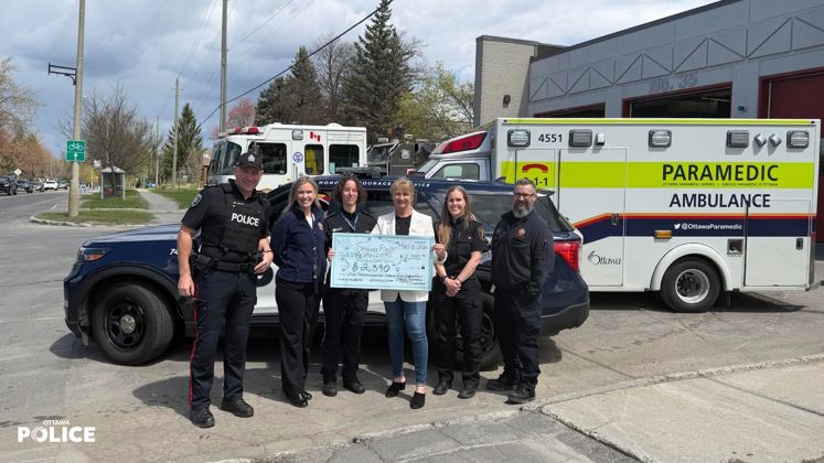 Des membres de la police d'Ottawa, des services paramedics d'Ottawa et d'incendie d'Ottawa présente un cheque à la fondation des premiers répondant d'Ottawa