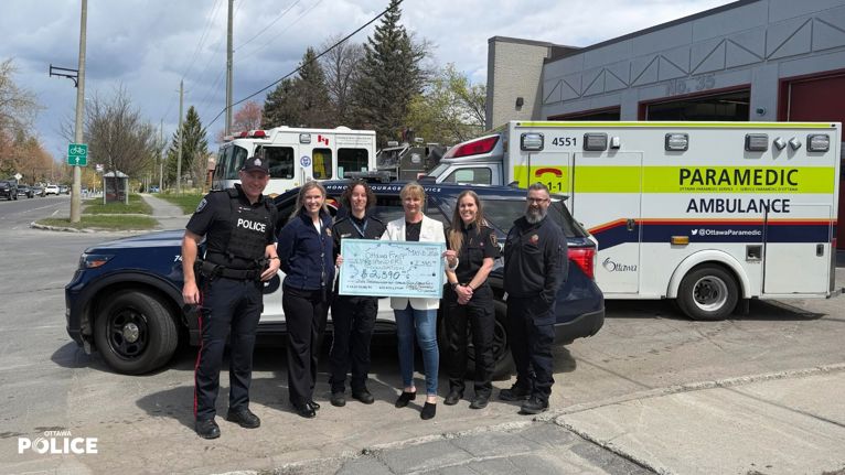 Members of ottawa police, ottawa fire and ottawa paramedics presenting a cheque to the ottawa first responders foundation.