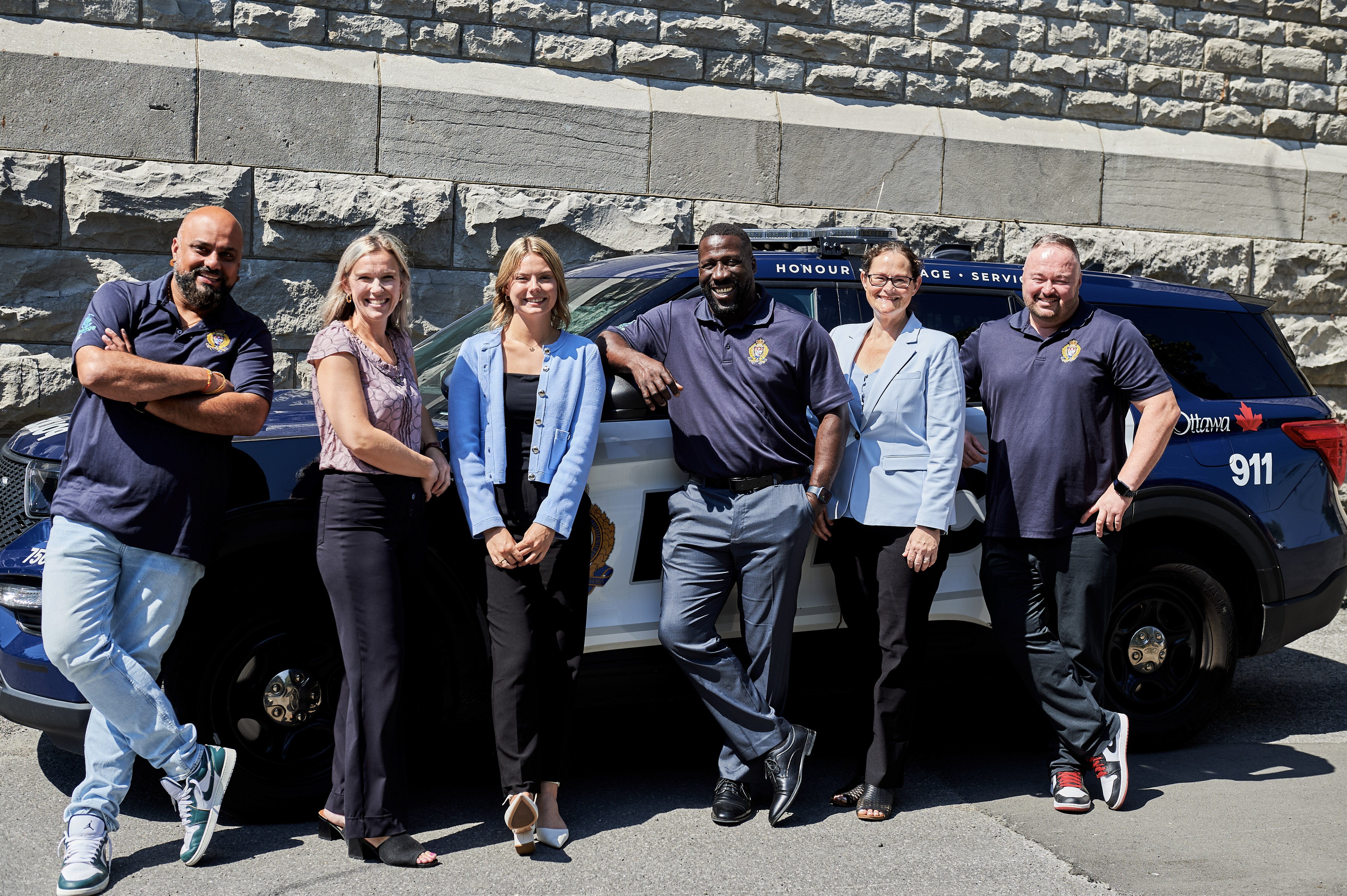 6 Ottawa Police members standing in front of an OPS cruiser