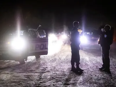 Ottawa Police officers standing in front of a cruiser discussing. / Des agents de police d'Ottawa discutent devant une voiture de patrouille. 