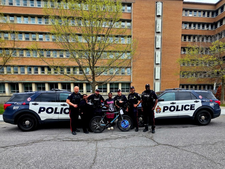 Group of officers with boy they gifted a bike to.