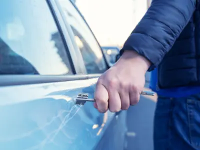 Person dragging a key along the side of a vehicle / Une personne qui frotte une clé contre le côté d'un véhicule