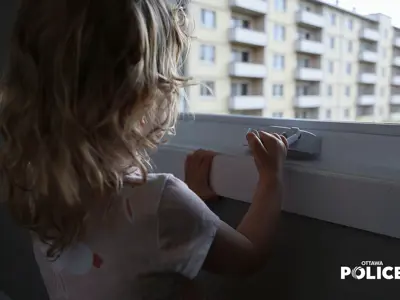 Child looking out the window of an apartment building