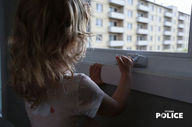 Un enfant regardant par la fenêtre d'un immeuble