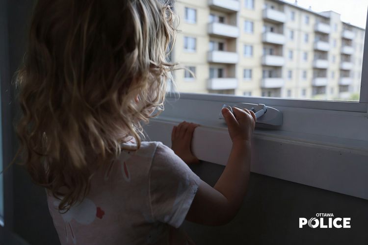Child looking out the window of an apartment building
