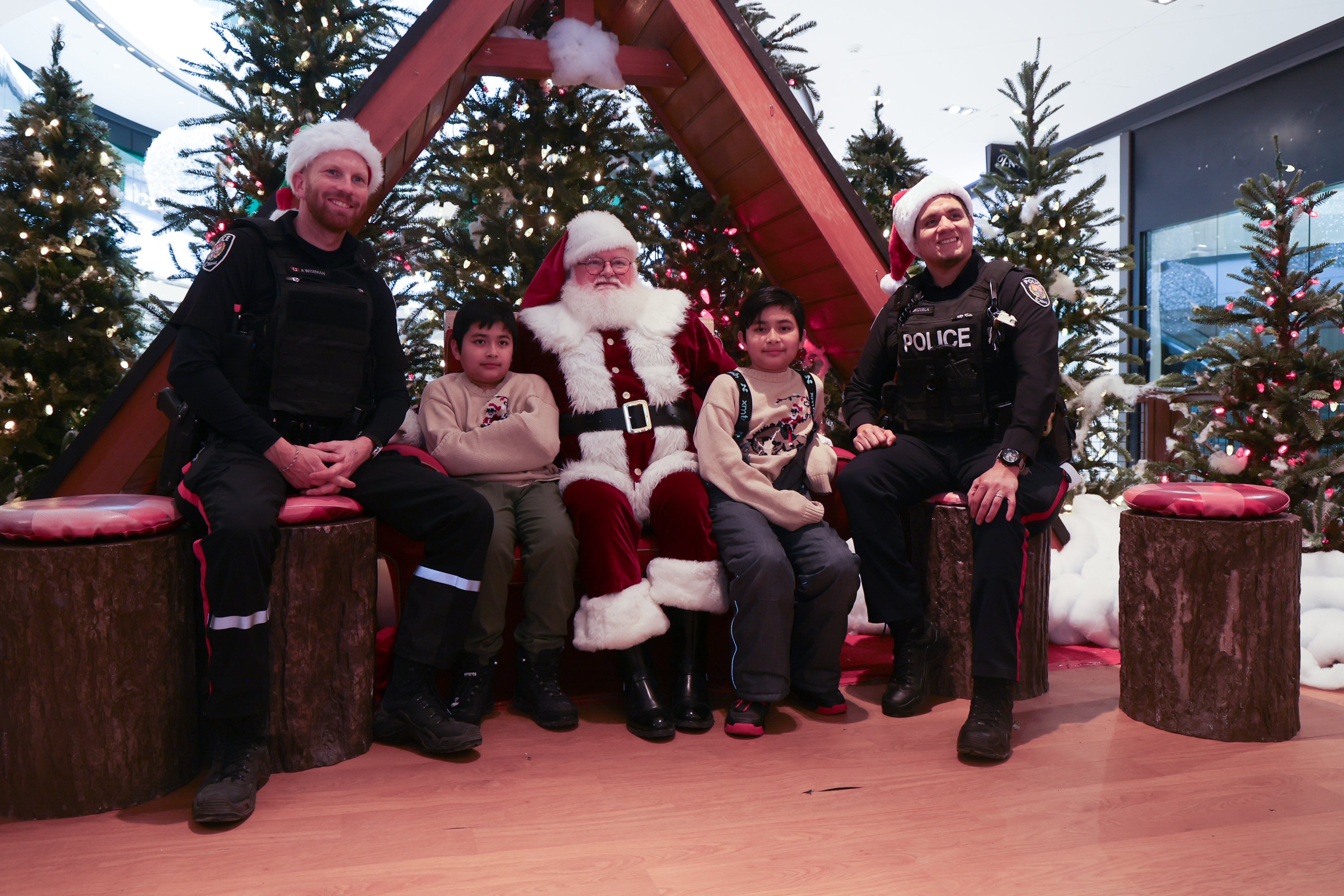 Kids, officers with Santa during Shop with a Cop